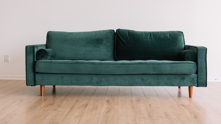 sofa-verde-sobre-suelo-de-madera