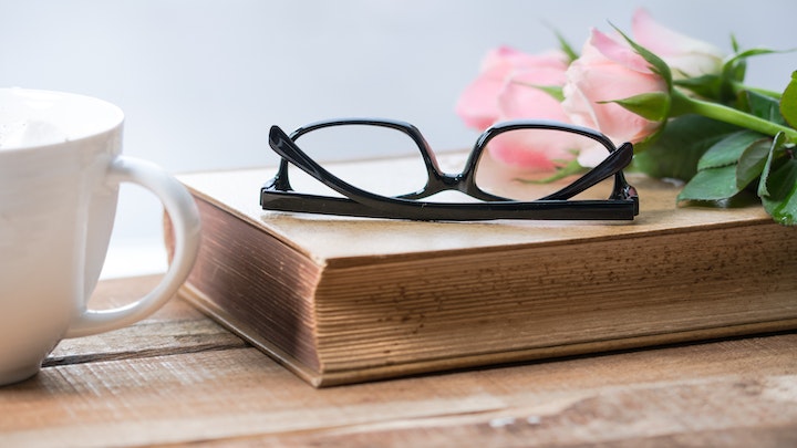 libro-gafas-y-flor-sobre-la-mesa
