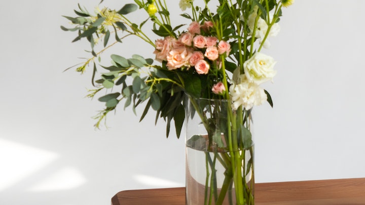 jarron-con-flores-sobre-mesa-de-madera