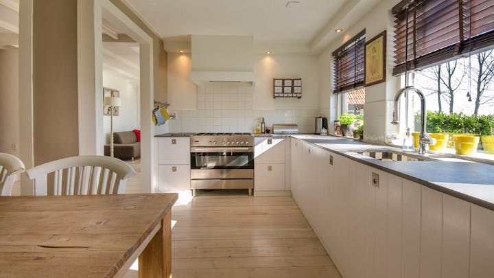 cocina-con-muebles-blancos-y-una-mesa-de-madera